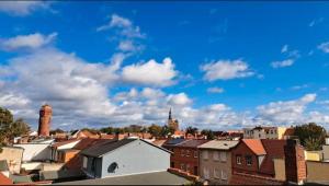 a city with buildings and a blue sky with clouds at Altstadtblick in Tangermünde