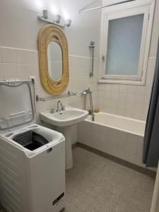 a bathroom with a sink and a tub and a mirror at Maison ancienne 163 avenue François Verdier albi in Albi