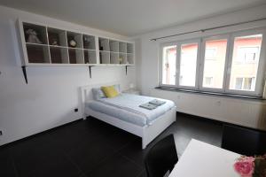 Una habitación blanca con una cama y una ventana en Apartment near train station, en Luxemburgo