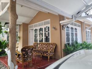 a porch with a couch and chairs and a tree at Homes stay Lily in Semplak