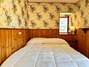 ein Schlafzimmer mit einem Bett in einem Zimmer mit Holzwänden in der Unterkunft Cozy Three-Room Apartment with Mountain View & Parking - Ussin Chalet - Valtournenche in Chamois