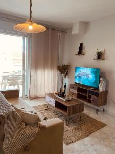 a living room with a couch and a tv at Vaso Apartment in Neos Marmaras