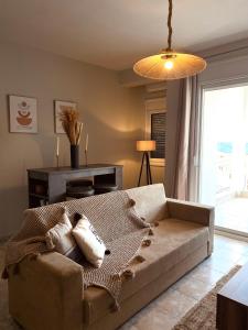 a living room with a couch and a large window at Vaso Apartment in Neos Marmaras
