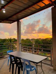 a table and chairs on a balcony with a view of the sunset at Second Pad at Second floor in Bolinao