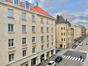 una calle de la ciudad con coches estacionados al lado de los edificios en Puma's central flat 2 in Helsinki, en Helsinki