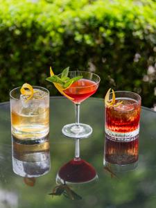 three cocktails sitting on top of a table at Rocco Forte The Charles Hotel in Munich