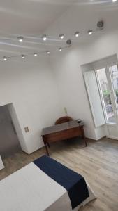Un dormitorio con una cama y un escritorio y una ventana. en Pomona Guest House, en Salerno