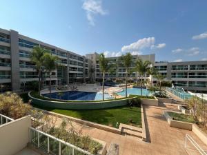 an apartment complex with two pools and palm trees at Flat na Beira do Lago in Brasilia