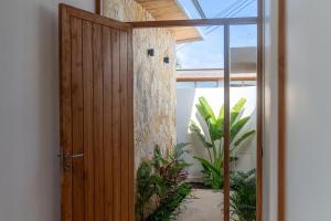an open wooden door in a room with plants at Villa Lucilla, beautiful Villa in the heart of Uluwatu in Uluwatu +37 photos
