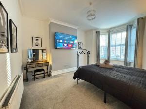 a bedroom with a bed and a tv and a desk at Park Apartment 1, close to Tynemouth in Tynemouth