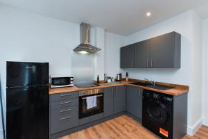 een keuken met een zwarte koelkast en een vaatwasser bij Charming 2Bed Flat - Spacious & Prime Location in Nottingham