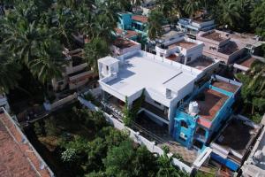 an overhead view of a white house with palm trees at White Home Stay in Kanyakumari