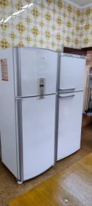 two white refrigerators sitting next to each other in a room at Casa espaçosa pertinho da praia in Santos +99 photos