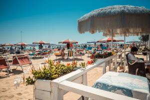 una spiaggia con sedie, tavoli e ombrelloni di Hotel Missouri a Bellaria-Igea Marina