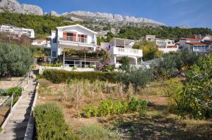 a house with a garden with mountains in the background at Apartments Niko in Pisak
