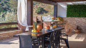 drewniany stół i krzesła na patio w obiekcie Cortijo El Manzano Salvatierra Torrox by Ruralidays w mieście Torrox