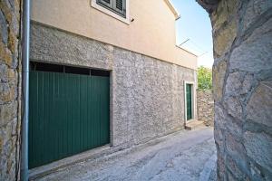 a green garage door on the side of a building at Apartment Afitojen in Postira +18 photos