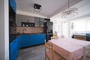 a kitchen and dining room with blue cabinets and a table at Apartment Afitojen in Postira