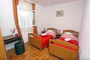ein Zimmer mit zwei Betten und einem Tisch und einem Fenster in der Unterkunft Apartment Marija in Drvenik Mali
