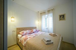 a bedroom with a bed with two towels on it at Apartment Afitojen in Postira