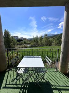 a table and chairs on a balcony with a view at Vue lac - T2 rénové - Parking - 4 pers in Gap