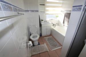 a bathroom with a toilet and a tub and a sink at Jakaranda 22 apartment, Uvongo in Uvongo Beach +27 photos