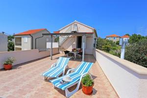 eine Terrasse mit 2 Stühlen und einem Tisch auf dem Dach in der Unterkunft Apartment Marija in Drvenik Mali