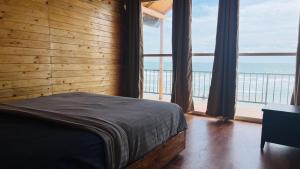 a bedroom with a bed with a view of the ocean at Sameer beachfront Cottages in Canacona