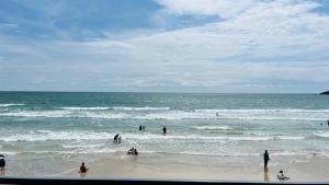 a group of people playing in the water at the beach at Sameer beachfront Cottages in Canacona