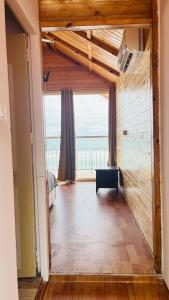 a living room with a large window and a room with a table at Sameer beachfront Cottages in Canacona