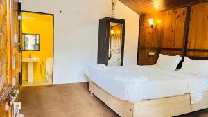 a bedroom with a large bed and a sink at Sameer beachfront Cottages in Canacona