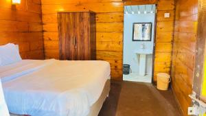a bedroom with a bed and a bathroom with a sink at Sameer beachfront Cottages in Canacona