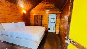 a bedroom with a bed in a wooden cabin at Sameer beachfront Cottages in Canacona