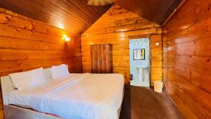 a bedroom with a bed in a wooden room at Sameer beachfront Cottages in Canacona