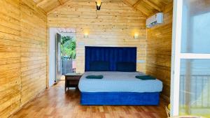 a bedroom with a bed and a wooden wall at Sameer beachfront Cottages in Canacona