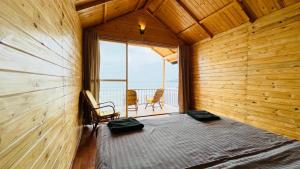 a bedroom with a bed in a wooden wall at Sameer beachfront Cottages in Canacona