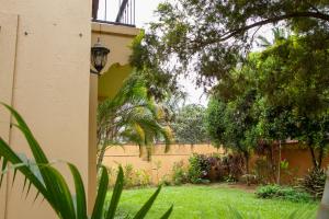 a house with a yard with grass and a fence at Family 3bed House in Kampala