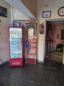 a coca cola refrigerator and a mirror in a room at Braj Pushp Guest House in Mathura
