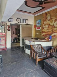 a room with a counter and chairs in a room at Braj Pushp Guest House in Mathura