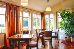 een eetkamer met tafels, stoelen en ramen bij Hotel Auf Wolke 8 in Trostberg an der Alz