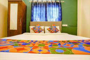 a bedroom with a bed with a colorful bedspread at FabHotel Diamond Stay in Pune