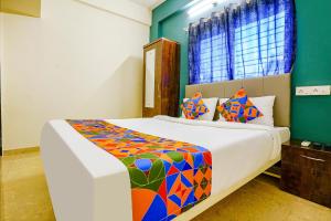 a bedroom with a large bed with a colorful blanket at FabHotel Diamond Stay in Pune