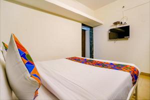 a bedroom with a bed with a colorful blanket at FabHotel Diamond Stay in Pune +21 photos