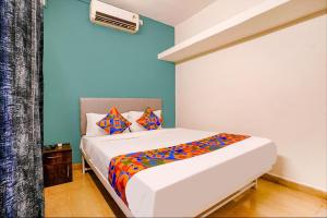 a bedroom with a bed with a colorful comforter at FabHotel Diamond Stay in Pune