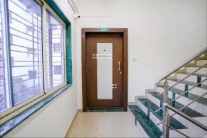 a hallway with a door and stairs in a building at FabHotel Diamond Stay in Pune