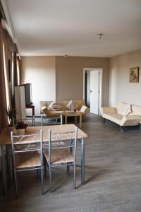 un soggiorno con divano, tavolo e sedie di Ambassador Suites Antwerp ad Anversa