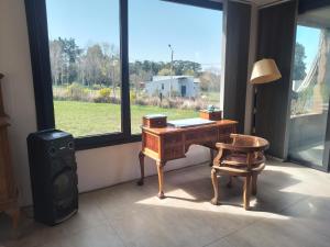 ein Zimmer mit einem Schreibtisch und einem Stuhl und einem Fenster in der Unterkunft La Elenitaland in Tandil