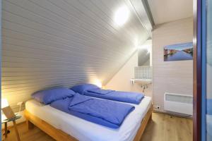 une chambre avec un grand lit avec des oreillers bleus dans l'établissement Haus Sonnenschein, Seepark Kirchheim, à Kirchheim