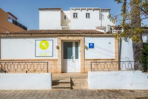坎帕斯蒂利亚Mallorca Rooms Can Pastilla的门上标有标志的白色建筑