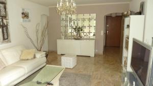 芒德留拉納普勒的住宿－Plein Soleil，客厅配有白色沙发和电视